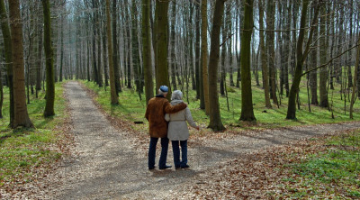 Äldre par som går tillsammans i en skog.